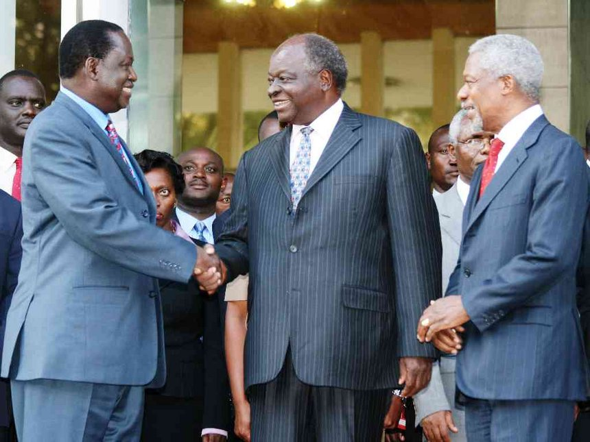 Former UN secretary general Kofi Anan watches as Opposition leader Raila Odinga and President Mwai Kibaki shake hands outside Harambee House, after brokering a peace deal in 2008 following post-election violence